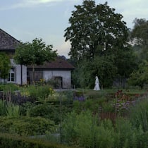 Als wäre die Zeit stillgestanden: Die Novizin Schwester Sara auf ihren abendlichen Runden durch den Klostergarten. Im Hintergrund die Wasch-und Arbeitsräume, in denen die Heilkräuter zu Teemischungen und Salben verarbeitet werden.