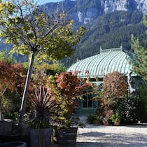 Filigranes Glashaus vor schroffer Felswand: Die Berge als Kulisse geben der Bühne – dem Garten – einen starken Ausdruck.