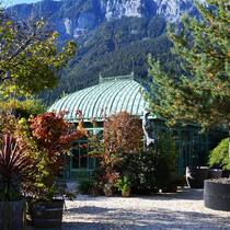 Filigranes Glashaus vor schroffer Felswand: Die Berge als Kulisse geben der Bühne – dem Garten – einen starken Ausdruck.