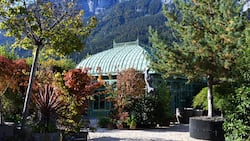 Filigranes Glashaus vor schroffer Felswand: Die Berge als Kulisse geben der Bühne – dem Garten – einen starken Ausdruck.
