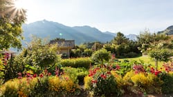 Der Blick schweift über fröhlich blühende Blumen- und Gemüsebeete bis zu den pittoresken Berner Voralpen.