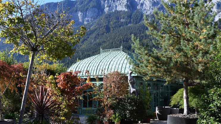 Filigranes Glashaus vor schroffer Felswand: Die Berge als Kulisse geben der Bühne – dem Garten – einen starken Ausdruck.