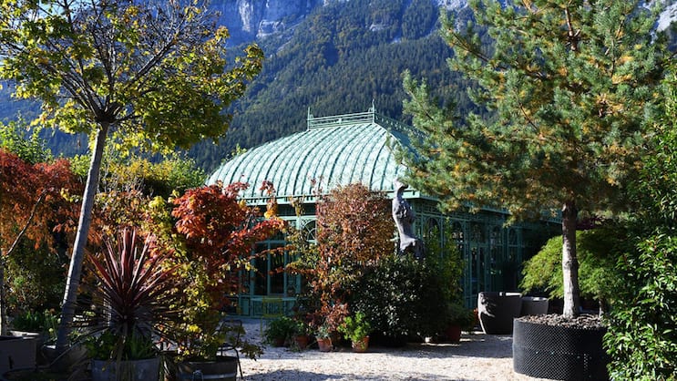 Filigranes Glashaus vor schroffer Felswand: Die Berge als Kulisse geben der Bühne – dem Garten – einen starken Ausdruck.