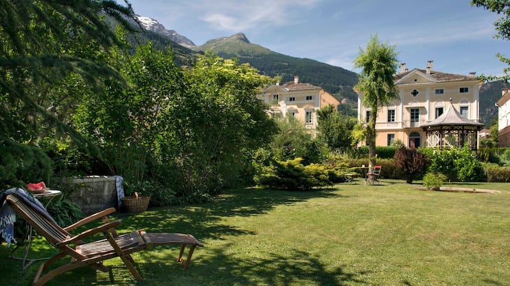 Umgeben von Natur und Bergen lässt sich hier wunderbar ruhen: Vom hinteren Teil des Areals schweift der Blick über die Gartenanlage mit einem nostalgischen Pavillon im Zentrum. Dahinter das Devon House, eingerahmt von den benachbarten Palazzi, die alle nach Süden ausgerichtet sind.