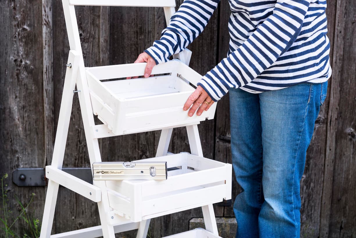 Sandra Dangel setzt Kistli ein in Pflanzentreppe und kontrolliert mit Wasserwaage