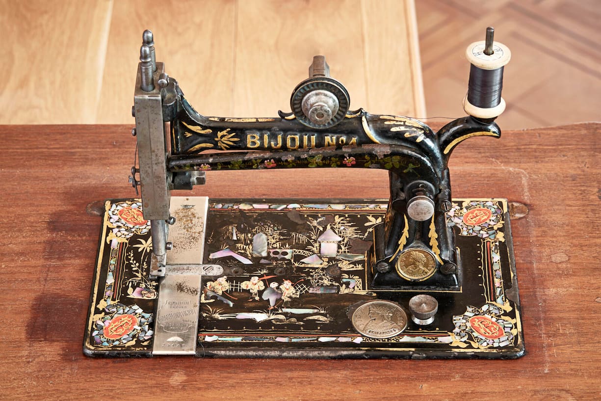 Naehmaschine mit schmuckvollen und glänzenden Einlagen aus Gold und Perlmutt