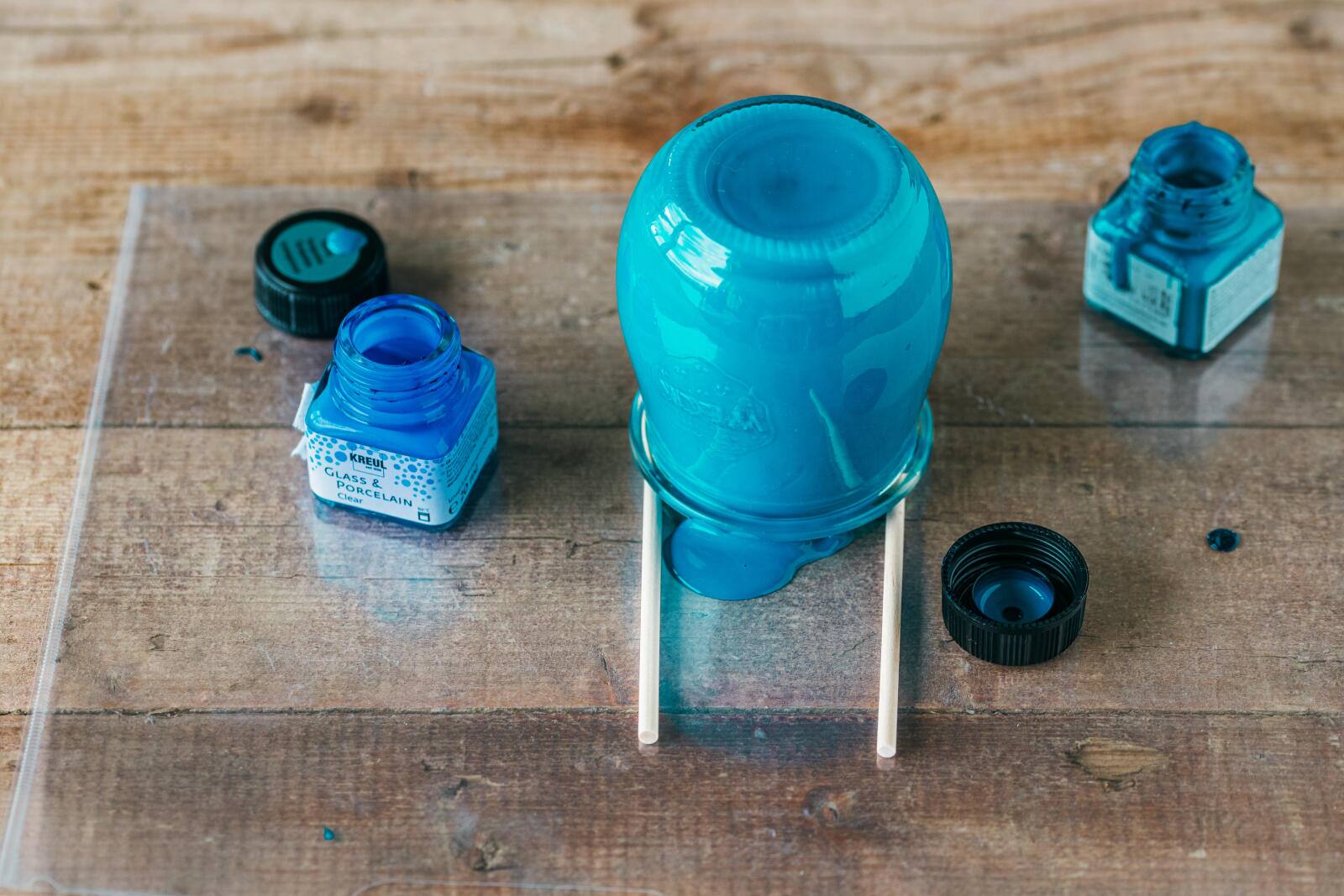 Umgekehrtes, eingefärbtes Glas auf Holzstäbli