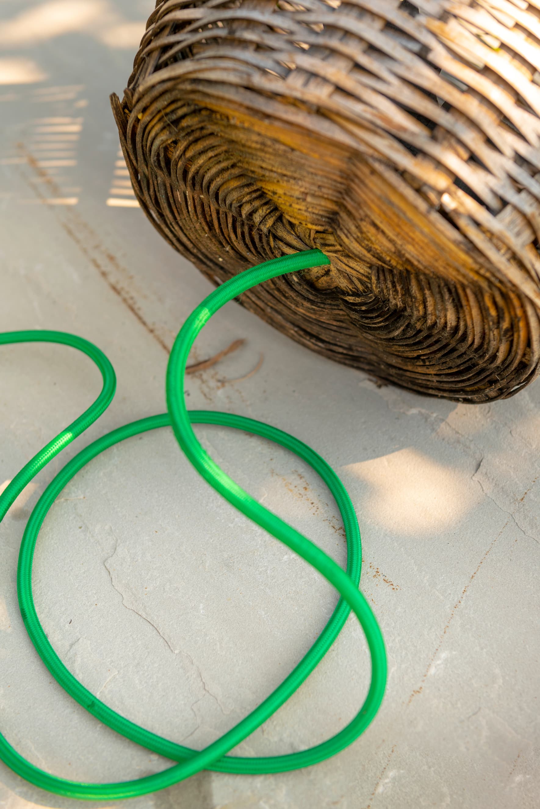 Korb mit Loch, durch das ein grünes Kabel gezogen wird