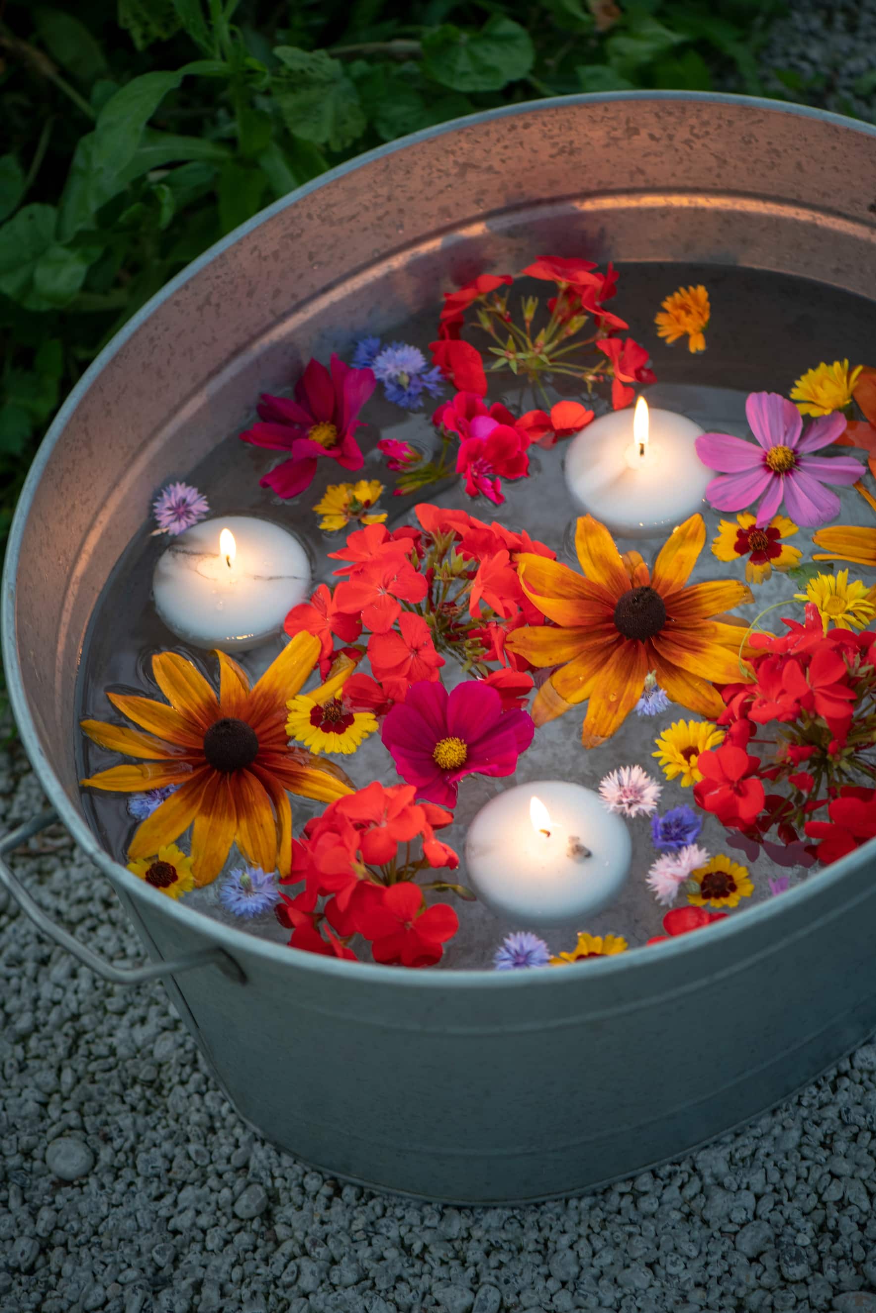 Ein Kessel mit Schwimmkerzen und farbenprächtigen Sommerblumen